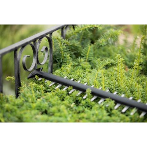 Bosch Universal Hedge Cut 18-55 akkus sövénynyíró használat közben egy sövényen.