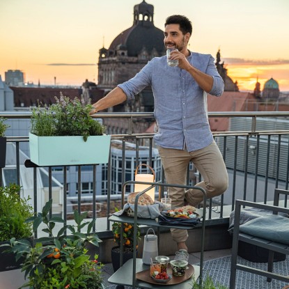Lechuza Balconera Color 50, pasztellzöld virágláda öntözőrendszerrel az erkélyen.