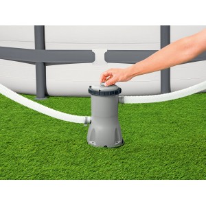 Bestway 3.028 l/h szűrőszivattyú a medence mellett a füvön, kéz a zárón.