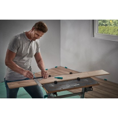 Férfi laminált/design padlóhoz való wolfcraft illesztőkészletet használ egy laminált darab megjelöléséhez.