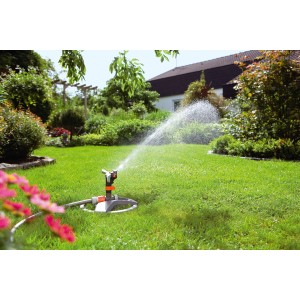 Gardena Premium gyepszóró szánnal öntözi a gyepet a kertben.