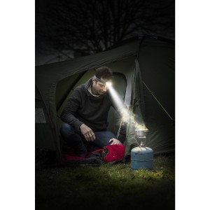 Férfi Energizer Vision HD fejlámpával főz a sátor előtt. Fényes fejlámpa.