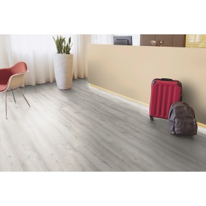 Kaindl Masterfloor Laminált padló 12 mm Tölgy Historic Arctic. Nappali jelenet bőrönddel és hátizsákkal.
